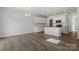 Open-concept living area and kitchen with hardwood floors, white cabinets, stainless appliances, and island at 2712 Lehigh Rd, Charlotte, NC 28208