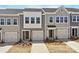 Charming new construction townhomes showcasing varied light gray siding, individual garages, and manicured landscaping at 2720 Lehigh Rd, Charlotte, NC 28208