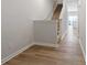 Bright hallway with hardwood floors leading to the kitchen, staircase on the left with carpeted steps at 2720 Lehigh Rd, Charlotte, NC 28208