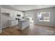 Eat-in kitchen with white cabinets, granite countertops, stainless steel appliances, and hardwood floors at 2720 Lehigh Rd, Charlotte, NC 28208