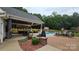 Expansive backyard featuring a covered patio with an outdoor kitchen, a pool, and lush greenery at 2763 Rivendale Ct, Indian Land, SC 29707