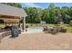 Beautiful backyard features a covered patio, inviting pool, and lush landscaping at 2763 Rivendale Ct, Indian Land, SC 29707