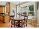 Cozy breakfast nook featuring hardwood floors, large windows overlooking the backyard, and a wooden table with chairs at 2763 Rivendale Ct, Indian Land, SC 29707