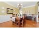 Formal dining area featuring wood flooring, natural light, decorative lighting, and bright yellow paint at 2763 Rivendale Ct, Indian Land, SC 29707