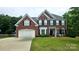 Beautiful two-story brick home with a well-manicured lawn, attached garage, and classic architectural details at 2763 Rivendale Ct, Indian Land, SC 29707