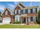 Traditional two-story brick home featuring black shutters, bay window, well-kept lawn, and an attached two-car garage at 2763 Rivendale Ct, Indian Land, SC 29707