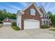 Two-car garage is attached to this beautiful two-story brick house with lush landscaping at 2763 Rivendale Ct, Indian Land, SC 29707