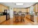 Bright kitchen featuring hardwood floors, ample cabinet space, stainless steel appliances, and an island with seating at 2763 Rivendale Ct, Indian Land, SC 29707