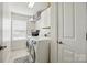 Bright laundry room features a modern washer and dryer, storage shelves, and natural light at 2763 Rivendale Ct, Indian Land, SC 29707