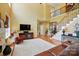 Spacious living room featuring tall ceilings, hardwood floors, a large window, staircase and comfortable furniture at 2763 Rivendale Ct, Indian Land, SC 29707