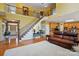 Spacious living room featuring tall ceilings, hardwood floors, a staircase, and comfortable leather furniture at 2763 Rivendale Ct, Indian Land, SC 29707