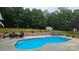 Beautiful backyard featuring an in-ground pool, lounge chairs, dining area, and lush landscaping at 2763 Rivendale Ct, Indian Land, SC 29707