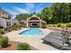 A lovely backyard featuring an in-ground pool, covered outdoor living space, and lounge chairs at 2763 Rivendale Ct, Indian Land, SC 29707