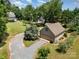 Scenic aerial view of a home nestled amongst lush greenery, boasting a long driveway and well-manicured yard at 2845 Lakefront Dr, Belmont, NC 28012
