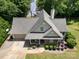 Aerial view of the home featuring a beautiful landscape, well-manicured lawn, and a two-car garage at 2845 Lakefront Dr, Belmont, NC 28012