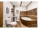 Unique bathroom with a tiled bathtub, pedestal sink, and rustic wood accents, offering a cozy, spa-like retreat at 2845 Lakefront Dr, Belmont, NC 28012