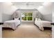 Bright bedroom featuring two twin beds, carpet floors, and a large window with natural light at 2845 Lakefront Dr, Belmont, NC 28012