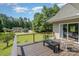 A backyard deck view featuring two patio chairs, a small table, and overlooking a large grassy lawn at 2845 Lakefront Dr, Belmont, NC 28012