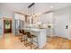 Modern kitchen featuring white cabinets, stainless steel appliances, an island with seating, and hardwood floors at 2845 Lakefront Dr, Belmont, NC 28012