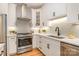 Well-lit kitchen featuring white cabinets, stainless steel appliances, modern fixtures, and hardwood floors at 2845 Lakefront Dr, Belmont, NC 28012