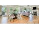 Bright open living room with a fireplace, hardwood floors, large windows, and a dining area with modern chairs at 2845 Lakefront Dr, Belmont, NC 28012