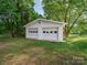 Detached two-car garage with white doors, set amidst a green lawn and mature trees at 300 W 12Th St, Salisbury, NC 28144