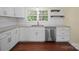Kitchen boasts white cabinets, stainless appliances, a modern faucet, and dark-stained wood floors at 300 W 12Th St, Salisbury, NC 28144