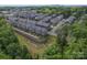 Aerial view of a townhouse community nestled among mature trees shows well-maintained landscaping and uniform architecture at 3003 Salix Bend Dr, Charlotte, NC 28205