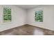 Empty bedroom features hardwood floors, white walls, base trim, and two large windows at 3003 Salix Bend Dr, Charlotte, NC 28205