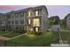 Beautiful townhome with stone accents, well-manicured lawn, and inviting curb appeal at dusk at 3003 Salix Bend Dr, Charlotte, NC 28205