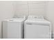 Laundry room with a white washer and dryer with metal rack above at 3003 Salix Bend Dr, Charlotte, NC 28205