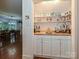 Dry bar area with ample shelving and cabinets in transition space between living and dining areas at 4951 Dayspring Dr, Mint Hill, NC 28227