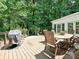Inviting backyard deck with outdoor seating and a grill, surrounded by lush greenery at 4951 Dayspring Dr, Mint Hill, NC 28227
