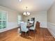 Elegant dining room featuring hardwood floors, wainscoting, and a chandelier over a dining table at 4951 Dayspring Dr, Mint Hill, NC 28227