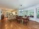 Open dining and kitchen area featuring hardwood floors, bright lighting, and a view of the outside at 4951 Dayspring Dr, Mint Hill, NC 28227