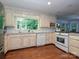 Charming kitchen with painted cabinets, stainless appliances, and a window view of mature trees at 4951 Dayspring Dr, Mint Hill, NC 28227