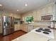 Well-lit kitchen with stainless steel appliances, hardwood floors, and backyard views at 4951 Dayspring Dr, Mint Hill, NC 28227