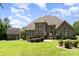 Well-manicured backyard with stone patio, lush greenery, and brick architecture enhances the home's appeal at 5183 Mill Race Ln, Lancaster, SC 29720