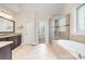 Bright bathroom features a glass-enclosed shower, separate bathtub, and a dark vanity with granite countertop at 5183 Mill Race Ln, Lancaster, SC 29720