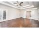 Spacious bedroom features hardwood floors, a tray ceiling, ceiling fan, and double doors to the outdoor patio at 5183 Mill Race Ln, Lancaster, SC 29720