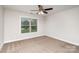 Cozy carpeted bedroom with a window, ceiling fan, and base trim that is waiting for a new owner at 5183 Mill Race Ln, Lancaster, SC 29720