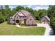 An eye-level view of a beautiful brick home featuring a large manicured lawn and three car garage at 5183 Mill Race Ln, Lancaster, SC 29720
