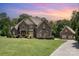 Charming home with manicured lawn, lush landscaping, and a long driveway leading to a separate garage at 5183 Mill Race Ln, Lancaster, SC 29720