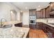 Modern kitchen with granite countertops, stainless steel appliances, and dark wood cabinets at 5183 Mill Race Ln, Lancaster, SC 29720