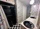 Full bathroom featuring black shower, black and white flooring, and unique newspaper wallpaper at 5495 Valley Run St, Hickory, NC 28601