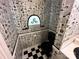 Stylish bathroom with unique newspaper wallpaper, black fixtures, and checkered tile flooring at 5495 Valley Run St, Hickory, NC 28601