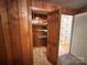 Closet with wood paneling and wire shelving, leading to a room with patterned wallpaper at 5495 Valley Run St, Hickory, NC 28601