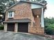 Side exterior of brick home featuring a two-car garage and a covered front porch at 5495 Valley Run St, Hickory, NC 28601