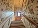 Bright foyer and staircase, features hardwood steps and floral wallpaper, chandelier, and front door at 5495 Valley Run St, Hickory, NC 28601