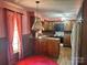 A cozy kitchen area with warm wood cabinets, red and white wallpaper accents, and essential appliances at 5495 Valley Run St, Hickory, NC 28601